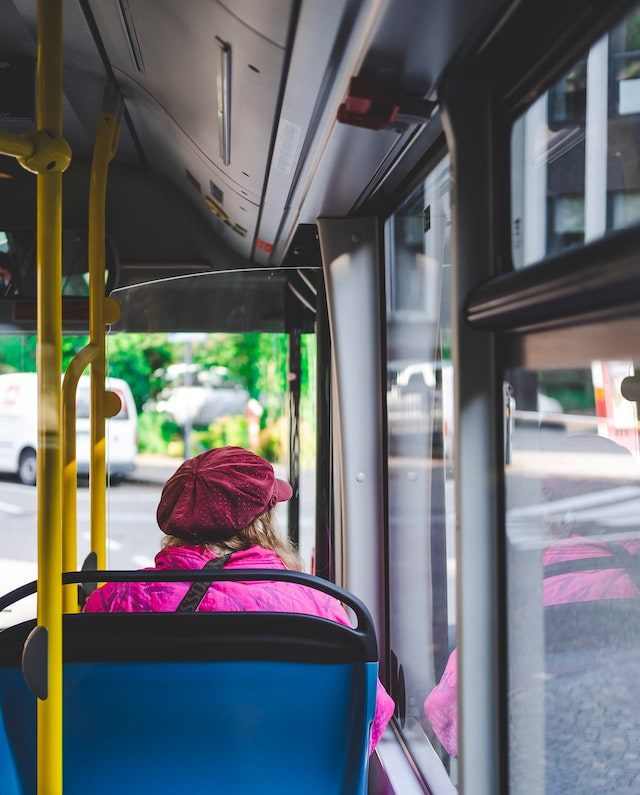 Dame sidder i bus ved siden af buschauffør på jobbet